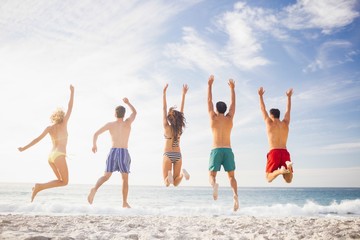 Wall Mural - Happy friends jumping together