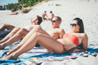 © Eugenio Marongiu - group of young multiethnic friends women and men at the beach in summertime tanning lying on their towel - summer, tanning, friendship concept