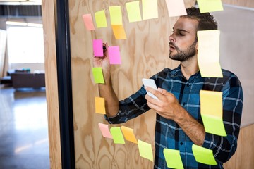 Aufkleber - Man using mobile phone while writing on sticky notes 