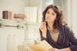 © ZoneCreative - young smiling brunette woman write in the kitchen