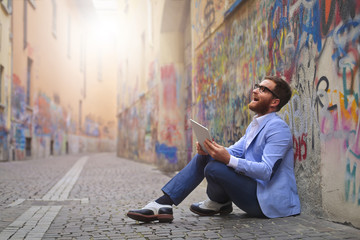 happy man with tablet in the street