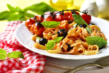 Pasta in tomato sauce with olives,basil and grilled cherry tomat