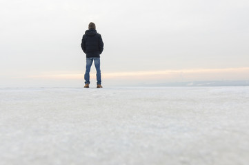 Back view of man standing on snow and watching nature