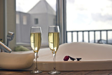 Two glasses of champagne near jacuzzi with strawberry and chocolate