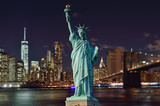 Fototapeta Miasta - Manhattah skyline with Brooklyn Bridge at night and Statue of Liberty.