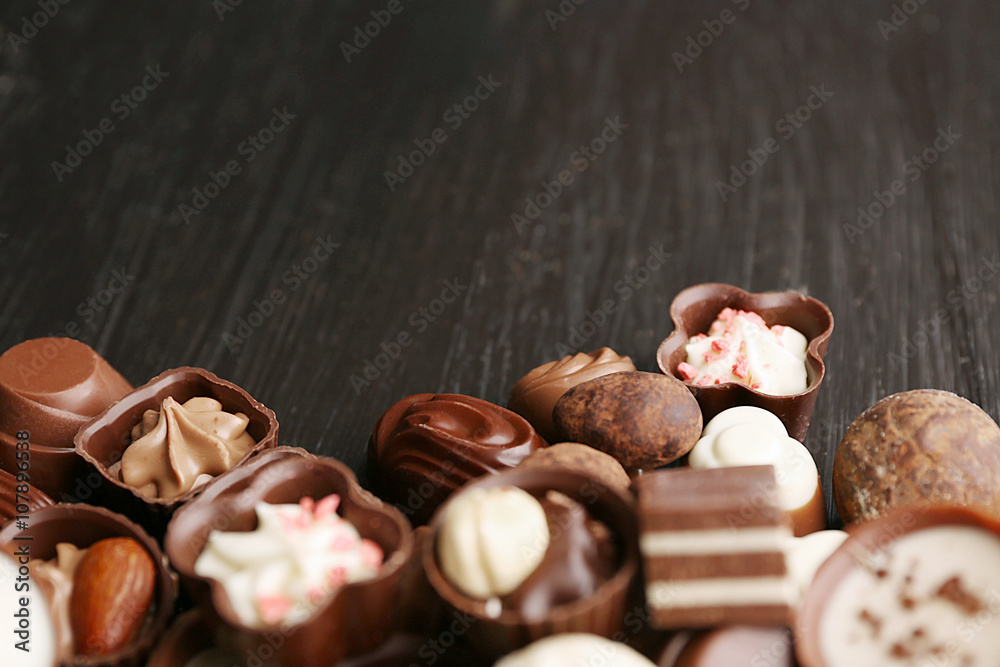 Delicious chocolate candies on wooden background, close up
