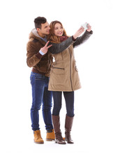 Young Couple Taking Selfie In Their Winter Clothes Isolated On White