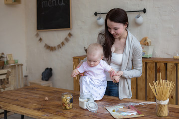 mother with her baby daughter in kitchen together cooking, lifes