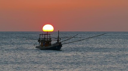 Wall Mural - fishing boat in the sea against the backdrop of the setting sun 4k
