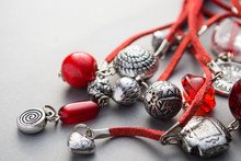 Close Up Of Red Glass Beads And Silver Charms