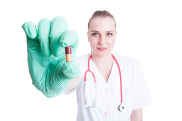 Attractive female doctor holding a two color pill