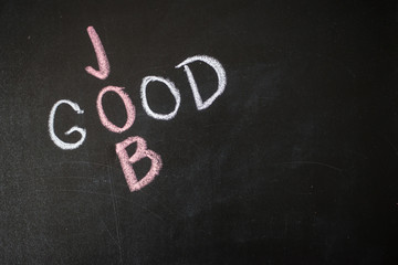 Good Job words written on blackboard over textured wall. Motivational concept.