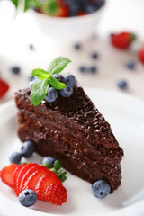 Sticker - Chocolate cake with chocolate cream and fresh berries on plate, on light background