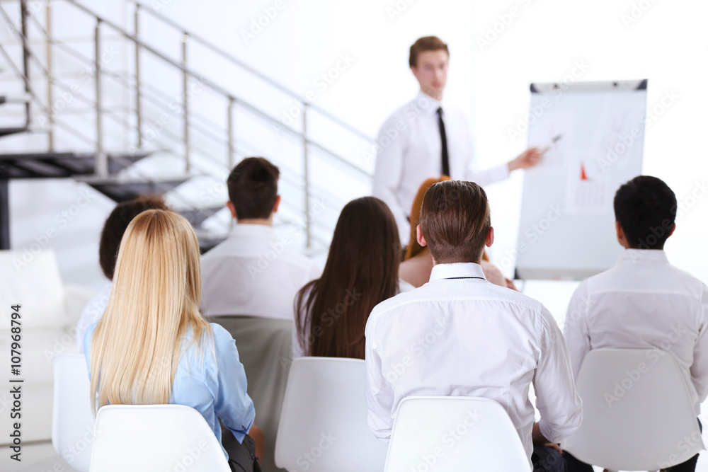 Young businessman making a presentation on a board in the office