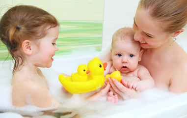 bathing in bath with foam mother together children baby