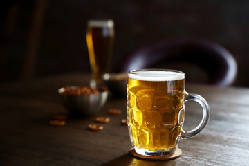 Wall Mural - Glass mug of light beer with snacks on wooden table