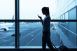 © kieferpix - Business travel concept. Woman at the airport using her smartphone.