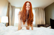 © NDABCREATIVITY - Seductive happy redhead woman in bedroom