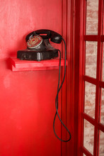 Red Telephone Booth In English Style. British Phone Box With Black Retro Telephone Standing In It. Vintage Looking Red Telephone Box.