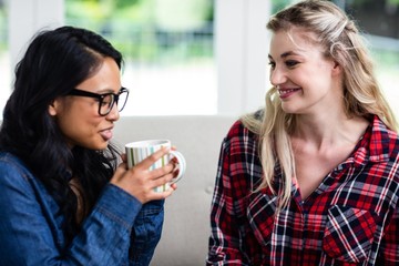 Wall Mural - Close-up of young female friends drinking coffee