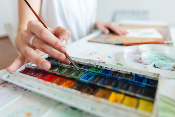 set of watercolor paints used by woman artist on table