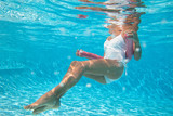 femme vue sous l'eau qui fait de l'aquagym