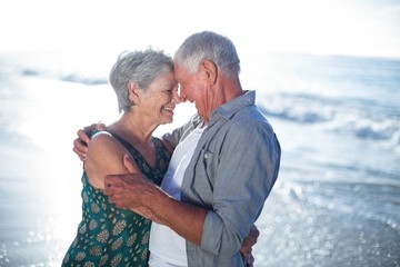 Wall Mural - Senior couple embracing at the beach