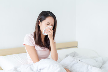 Wall Mural - Woman sneezing on bed