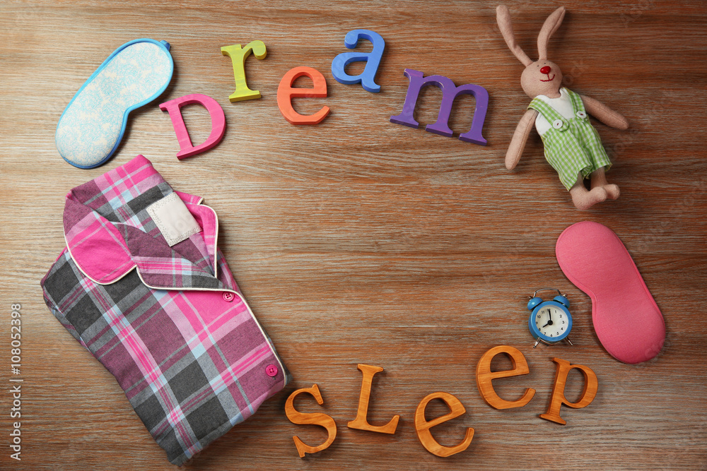 Insomnia concept with sleeping accessories on wooden table, top view