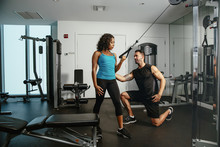Woman Working Out With Trainer In Gym