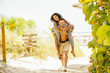 © Inti St Clair/Blend Images - Man carrying girlfriend piggyback on beach