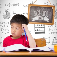 Canvas Print - Composite image of cute pupils writing at desk in classroom