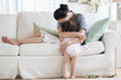 © JGI/Tom Grill/Blend Images - Mother hugging baby daughter on sofa