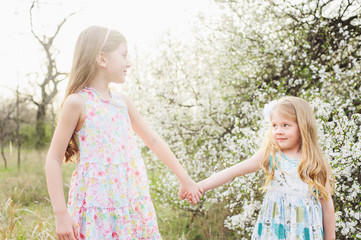 little girl in blooming  garden on beautiful spring day