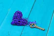 Purple Heart With House Key On Blue Background