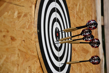 Close up of darts arrows being stuck in the target board