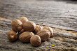 Dried nutmeg seeds set on old wooden surface