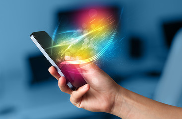 hand holding smart phone with abstract glowing lines