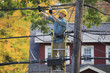 © Disability Images/Blend Images - Caucasian cable installer working on ladder