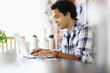 © JGI/Tom Grill/Blend Images - Mixed race man using laptop in coffee shop