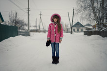 Caucasian Girl Standing On Snowy Street