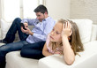 © Wordley Calvo Stock - internet addict father using mobile phone ignoring little sad daughter bored lonely and depressed
