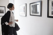 © JGI/Tom Grill/Blend Images - Hispanic woman admiring art in gallery