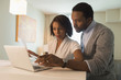 © Mark Edward Atkinson/Blend Images - Couple paying bills on laptop