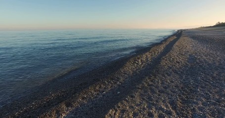 Wall Mural - 4k Empty Beach near the Calm Sea at the Sunset.