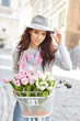 © ZoomTeam - stylish woman in gray hat on a bicycle with spring flowers on a