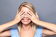thrilled sexy blond woman hiding eyes to express surprise