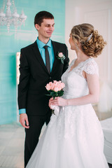 Happy couple. Wedding photo shoot in the white studio with wedding decor kisses, hugs