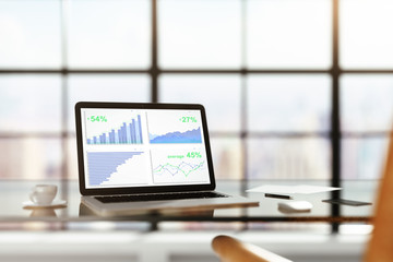 Poster - Laptop with financial statistics on a glass table with cup of co