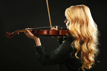 Poster - Musician plays violin on black background, close up